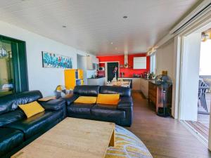 a living room with a leather couch and a kitchen at Les Tilleuls 4 in Saint-Gingolph