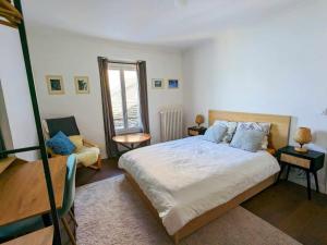a bedroom with a bed and a chair in it at Les Tilleuls 4 in Saint-Gingolph