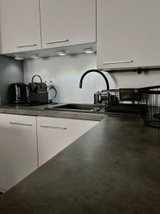 a kitchen with white cabinets and a sink at APARTAMENTY CENTRUM in Kostrzyn nad Odrą