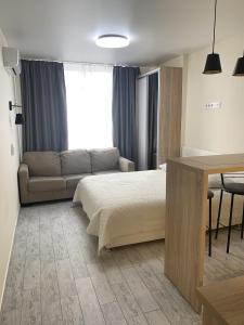 1 dormitorio con cama, sofá y mesa en Apartment Kiev Studio with city view, en Kiev