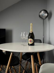 a bottle of champagne and two wine glasses on a table at APARTAMENTY CENTRUM in Kostrzyn nad Odrą