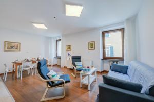 uma sala de estar com um sofá, cadeiras e uma mesa em Residenza Rocca Del Lago 4 em Riva del Garda