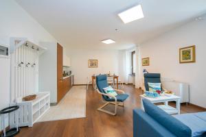 uma sala de estar com um sofá azul e cadeiras em Residenza Rocca Del Lago 4 em Riva del Garda