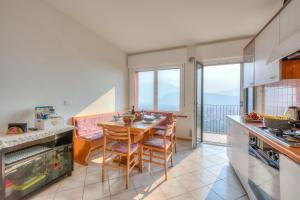 une cuisine avec une table et une salle à manger avec un balcon dans l'établissement Lake View Dom-Us Apartment, à Riva del Garda