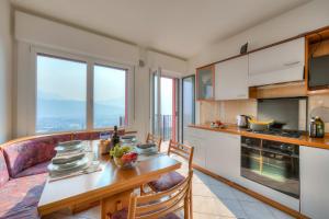 - une cuisine avec une table et un canapé ainsi que quelques fenêtres dans l'établissement Lake View Dom-Us Apartment, à Riva del Garda