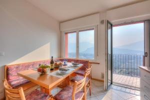 - une salle à manger avec une table, des chaises et des fenêtres dans l'établissement Lake View Dom-Us Apartment, à Riva del Garda
