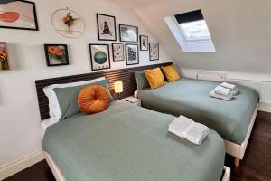 2 Betten in einem Zimmer mit Bildern an der Wand in der Unterkunft Superb Studio in Wembley 30min to Central London in London