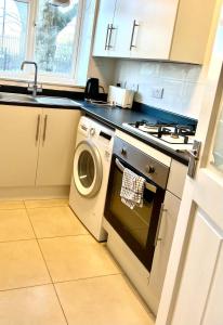 a kitchen with a washing machine and a sink at Private double room in the center of london in London