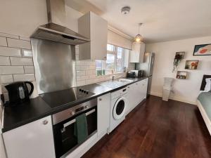 a kitchen with a sink and a washing machine at Superb Studio in Wembley 30min to Central London in London