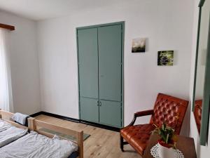 ein Schlafzimmer mit einem Schrank, einem Stuhl und einem Bett in der Unterkunft Ristorante Notari cà di gust vecc in Malvaglia