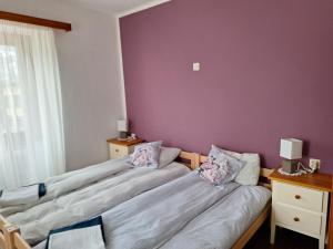 2 camas en una habitación con una pared púrpura en Ristorante Notari cà di gust vecc, en Malvaglia