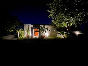 a house with an orange door in a yard at night at Welcome to the Jungle in Zihuatanejo