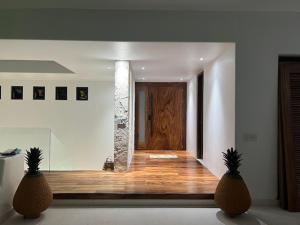 two pineapples sitting in front of a hallway with a door at Welcome to the Jungle in Zihuatanejo