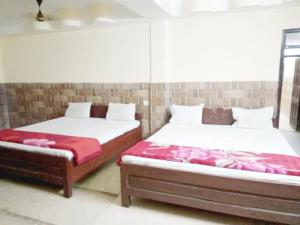 2 Betten nebeneinander in einem Zimmer in der Unterkunft Hotel Parteek Residency Near Amrabati Park - Bypass Road Digha in Digha