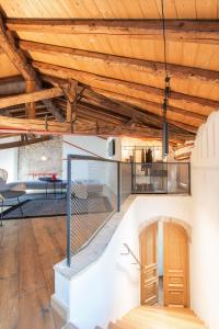 una sala de estar de planta abierta con techos de madera y una escalera. en Locanda Al Castelletto en Tremosine Sul Garda