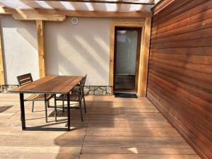 een houten tafel en stoelen op een patio bij Apartments Mrakič in Bovec