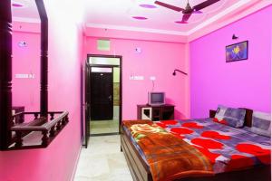 ein rosafarbenes Schlafzimmer mit einem Bett und einem TV in der Unterkunft Hotel Parteek Residency Near Amrabati Park - Bypass Road Digha in Digha