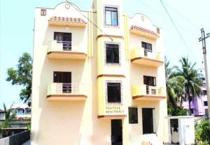 ein gelbes Gebäude mit Balkon an der Seite in der Unterkunft Hotel Parteek Residency Near Amrabati Park - Bypass Road Digha in Digha