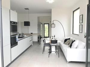 sala de estar blanca con sofá blanco y cocina en Skyline 360 Estate A secluded retreat stunning sea and mountain views, en Caccamo