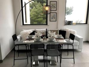 une salle à manger avec une table et des chaises blanches dans l'établissement Skyline 360 Estate A secluded retreat stunning sea and mountain views, à Caccamo