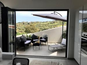 - un balcon avec un parasol, une table et des chaises dans l'établissement Skyline 360 Estate A secluded retreat stunning sea and mountain views, à Caccamo