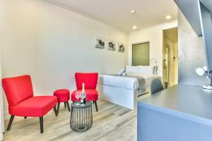 a hotel room with a bed and red chairs at 317 Alberts in Cape Town