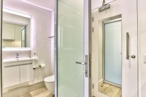 a bathroom with a toilet and a glass shower door at 317 Alberts in Cape Town