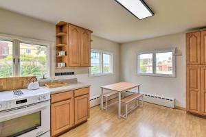 a kitchen with wooden cabinets and a table in it at Parkstrip Place, Pet Friendly Downtown Home in Anchorage