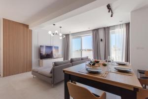 沙拉的住宿－Seaview And Wellness Penthouse In Gozo - Happy Rentals，厨房以及带桌椅的起居室。