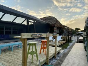 un complejo con un bar con dos taburetes y una piscina en Coastal Waterfront Home WithPool-Tiki-Dock home, en Bonita Springs