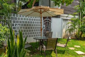 a table and chairs under an umbrella in a yard at Mammoth Boutique Hotel in Chiang Mai