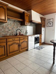 una cucina con armadietti in legno ed elettrodomestici bianchi di L’Hacienda, maison de caractère a Saint-Martin-de-Valamas Altre 7 foto