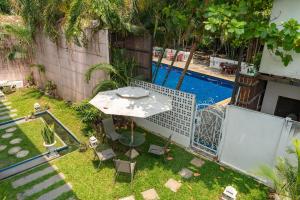 a small backyard with a table and chairs and a pool at Mammoth Boutique Hotel in Chiang Mai