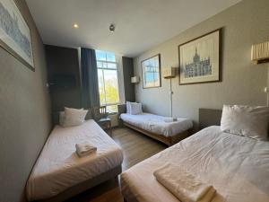 una camera d'albergo con due letti e due finestre di Di-Ann City Centre Hotel ad Amsterdam