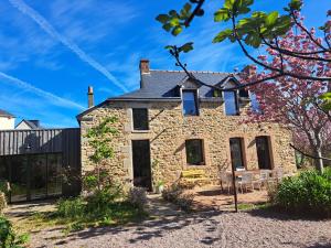 an old stone house with a table in front of it at 600m bord de mer centre du val andre la maison des prés in Pléneuf-Val-André