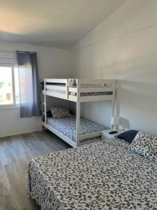 カラ・エン・ブラネスにあるApartamento Cala Piquesのベッドルーム1室(二段ベッド2台、窓付)が備わります。