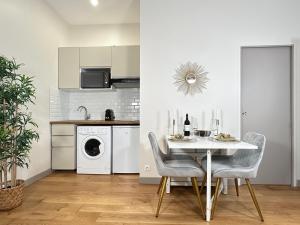 uma cozinha com uma mesa branca e cadeiras num quarto em 2063 - Orsay studio in Paris Olympic Games 2024 em Paris