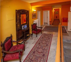 ナフプリオにあるByron Traditional Hotelのリビングルーム(椅子2脚、鏡付)
