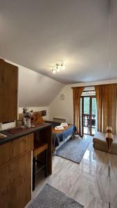 Il dispose d'une cuisine et d'un salon avec un canapé et une table. dans l'établissement Apartman Pavle, à Nova Varoš