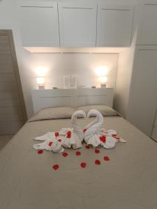 een bed met twee zwanen gemaakt van harten bij Storm Sonic House in Palo del Colle