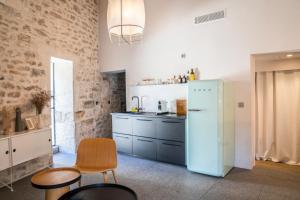 eine Küche mit einem blauen Kühlschrank und einigen Stühlen in der Unterkunft La Maison Favier in Saint-Rémy-de-Provence