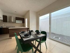 a dining room table with green chairs in a kitchen at Casa en Fraccionamiento Privado in Lázaro Cárdenas