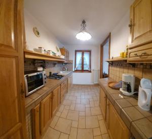 a large kitchen with wooden cabinets and a window at Ca'Capriolo in Taceno
