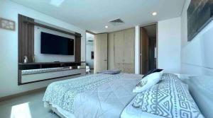 a bedroom with a large bed and a flat screen tv at Luxury Apartamento Hilton WI-FI, TV, Piscina y Gym in Barranquilla +21 photos