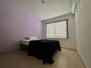 1 dormitorio con cama y ventana en Casa en Fraccionamiento Privado, en Lázaro Cárdenas