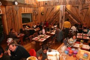 um grupo de pessoas sentadas em mesas em um restaurante em Chalet 4 étoiles - eeeaeh em Le Bourg-dʼOisans