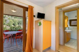 Zimmer mit einem Balkon mit einem Tisch und einem TV. in der Unterkunft Pian Dei Boschi - Superior 8 in Pietra Ligure