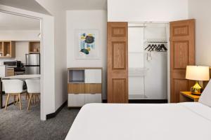 a hotel room with a bed and a kitchen at TownePlace Suites Chicago Lombard in Lombard