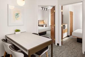 una habitación con mesa y sillas y un dormitorio en TownePlace Suites Chicago Lombard, en Lombard