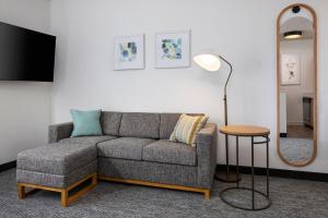 a living room with a couch and a floor lamp at TownePlace Suites Chicago Lombard in Lombard